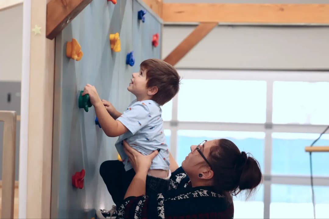 Child climbing with therapist help